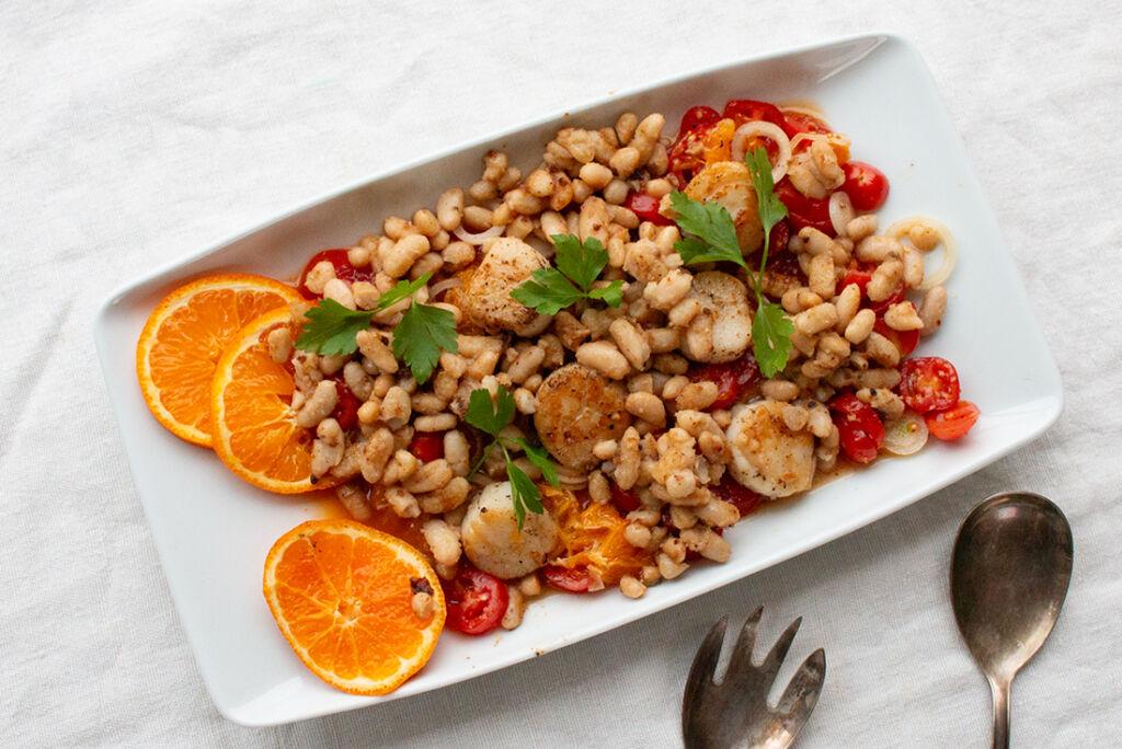 Gebratene Bohnen und Jakobsmuscheln auf Tomatensalat