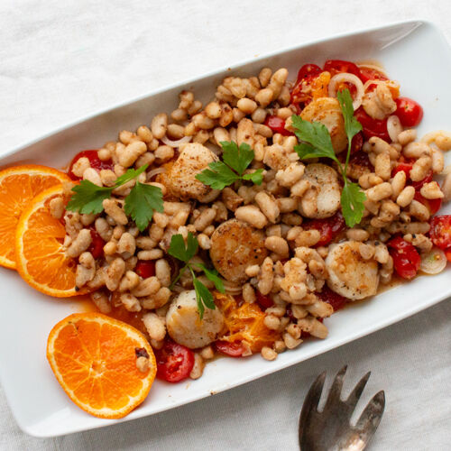 Gebratene Bohnen und Jakobsmuscheln auf Tomatensalat