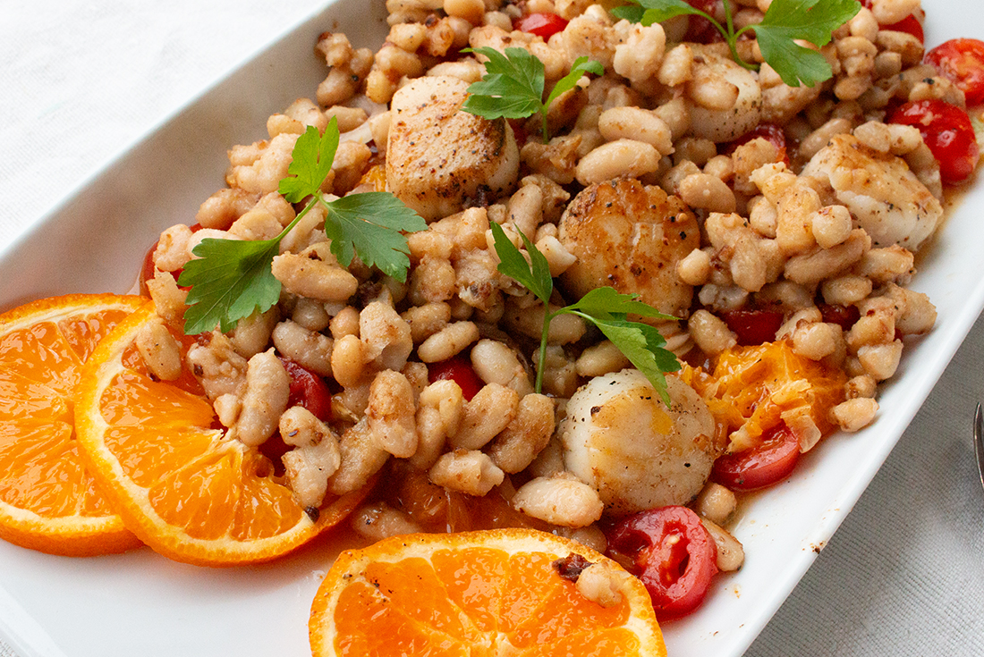 Gebratene Bohnen und Jakobsmuscheln auf Tomatensalat